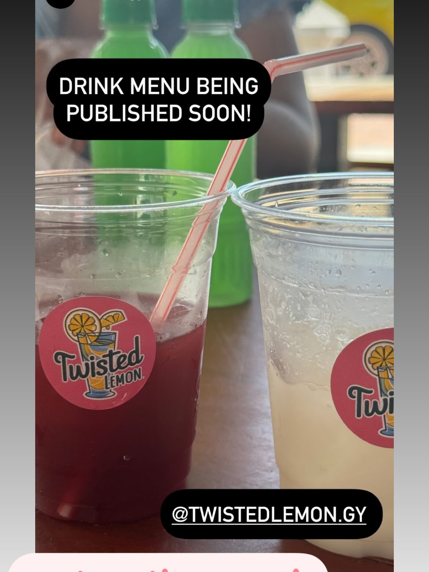 A guest happily sipping a Twisted Lemon drink at an outdoor table, with citrus cups and cold lemonade in front of her.